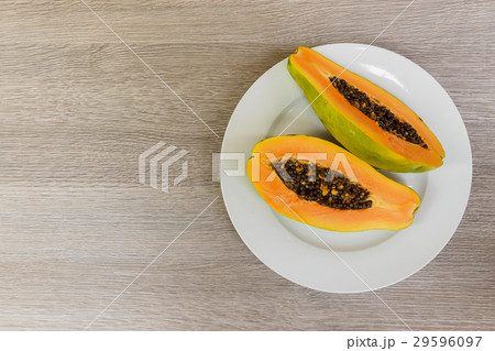 Slice of ripe papayas on wooden table  29596097