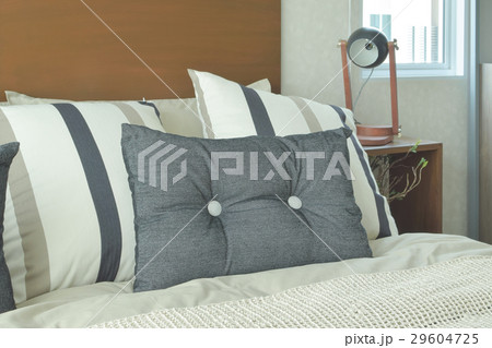 Gray and brown strip pillows setting on bed Gray and brown strip pillows setting on bed 29604725