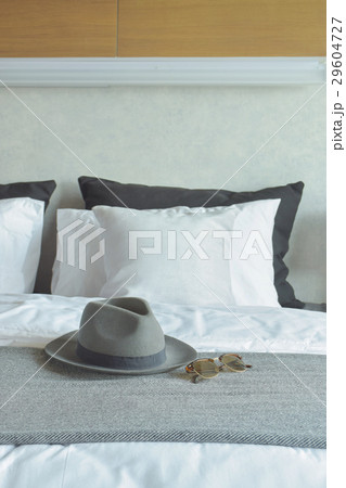 Gray hat and sunglasses on bed Gray hat and sunglasses on bed 29604727
