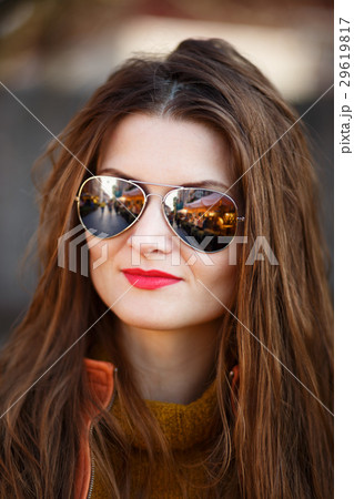 Outdoor portrait of young woman with curly hair 29619817