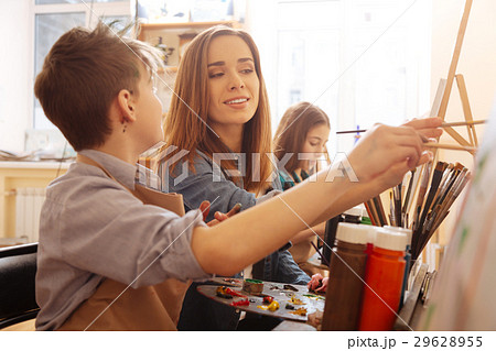 Charming young artist helping children in the art Charming young artist helping children in the art 29628955
