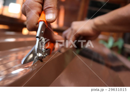 Workers use scissors to cut the metal sheet. Workers use scissors to cut the metal sheet. 29631015