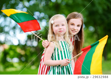Two pretty little sisters holding tricolor Lithuanian flags Two pretty little sisters holding tricolor Lithuanian flags 29632988