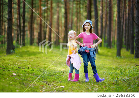 Two adorable little sisters hiking in a forest Two adorable little sisters hiking in a forest 29633250