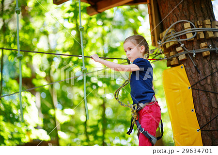 Adorable little girl enjoying her time in climbing adventure park 29634701