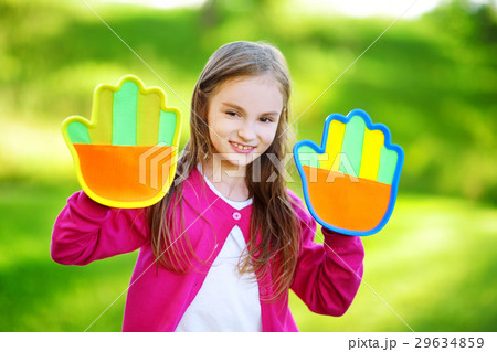 Cute little girl playing a ball catching game with sticky velcro palm pads 29634859