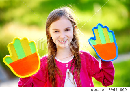 Cute little girl playing a ball catching game with sticky velcro palm pads 29634860