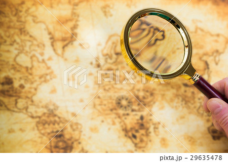Old map and magnifying glass in a hand 29635478