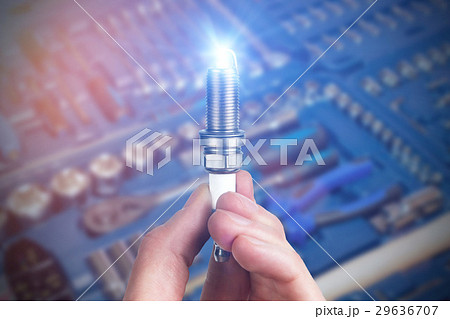 Mechanic holds a spare part spark plug in hand 29636707