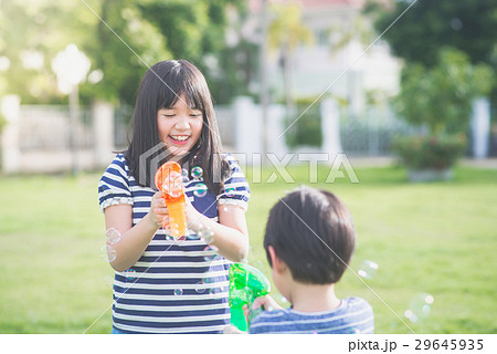 Asian chid Shooting Bubbles from Bubble Gun 29645935