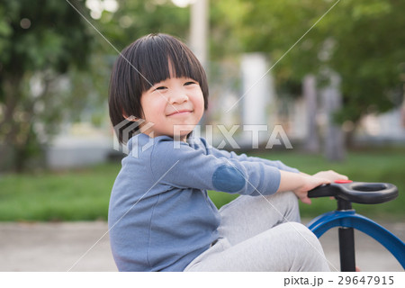 Asian child driving blue toy car outdoors 29647915