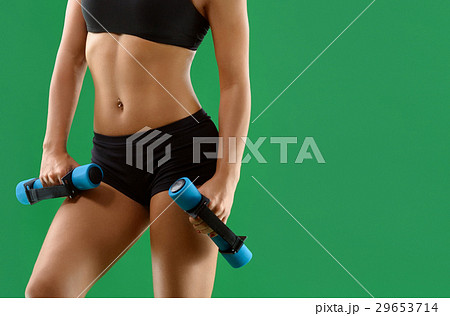 Young attractive woman with dumbbells in her hands Young attractive woman with dumbbells in her hands 29653714