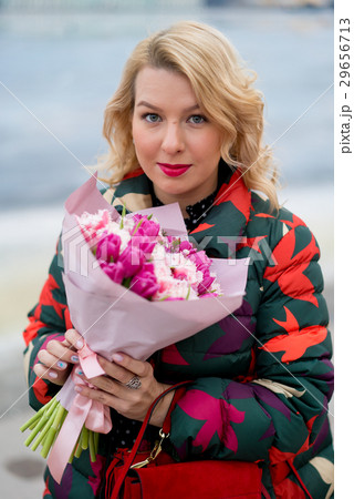 Young blonde woman with flowers bouquet on a city Young blonde woman with flowers bouquet on a city 29656713