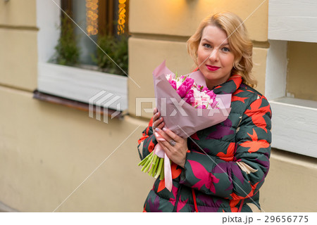 Young blonde woman with flowers bouquet on a city Young blonde woman with flowers bouquet on a city 29656775