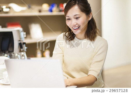 カフェでパソコンを使う若い女性 カフェでパソコンを使う若い女性 29657128