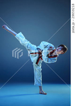 Young boy training karate on blue background 29659218