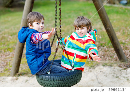 Two little kid boys having fun with chain swing on 29661154