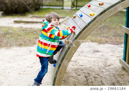 Happy blond kid boy having fun and climbing on 29661184