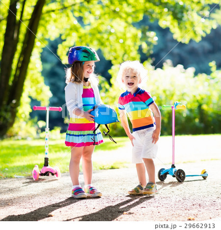 Kids riding scooter in summer park. 29662913