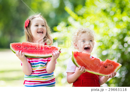Kids eating watermelon in the garden 29663118