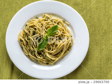 Portion of pasta with pesto sauce and basil leaf 29663700