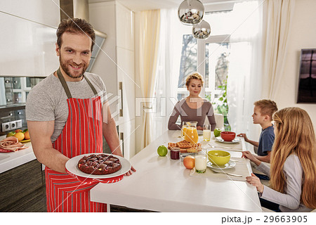 Happy father serving sweet food on table Happy father serving sweet food on table 29663905