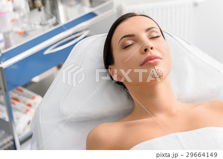 Serene woman with correction marks in clinic Serene woman with correction marks in clinic 29664149