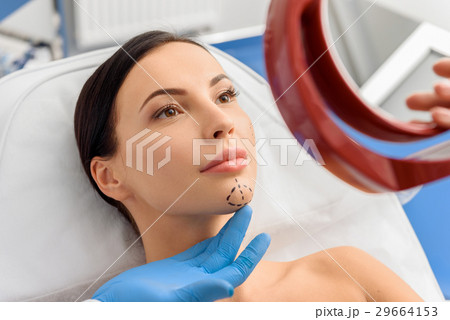 Serene female watching at reflection in hospital 29664153
