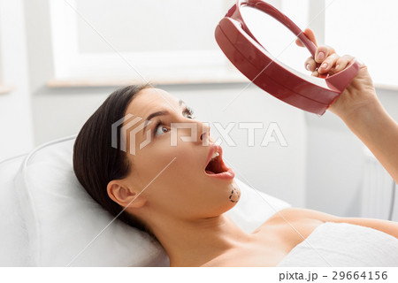 Amazed woman with perforation lines looking at 29664156