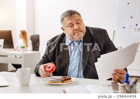 Busy engaged employee eating at his workplace 29664404