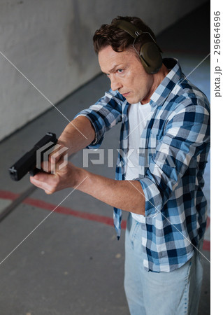 Handsome good looking man directing his handgun 29664696