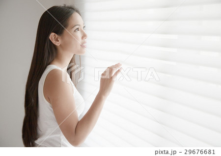 ブラインドに手をあてる若い女性 ブラインドに手をあてる若い女性 29676681