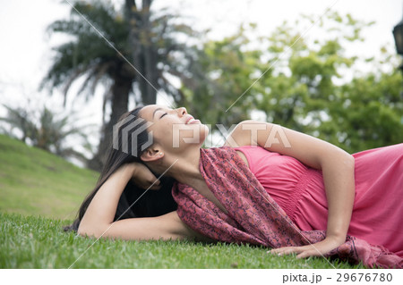 芝生に横たわる若い女性 29676780