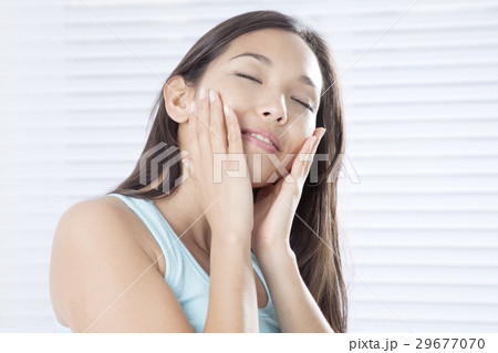 頬に手をあてる若い女性 頬に手をあてる若い女性 29677070