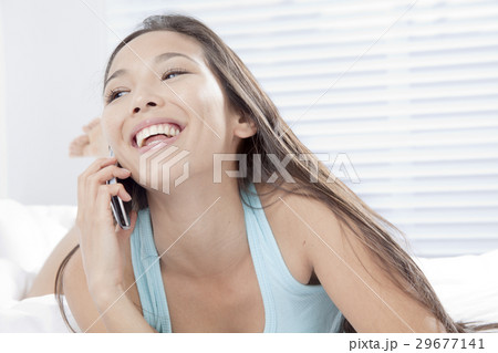携帯電話で通話する若い女性 29677141