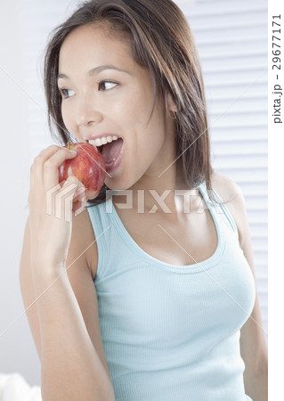りんごをかじる若い女性 29677171