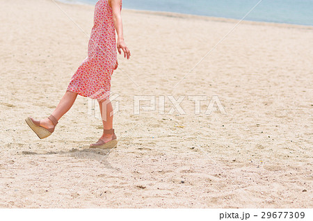 砂浜を歩く女性の足元の写真素材 砂浜を歩く女性の足元の写真素材