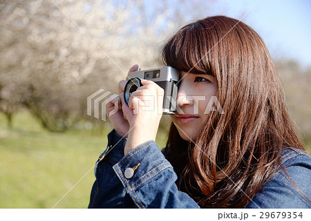 カメラ女子 カメラ 一眼レフ レトロ 女性 20代 桜 目線 花 ロング 長髪 かわいい の写真素材 29679354 Pixta