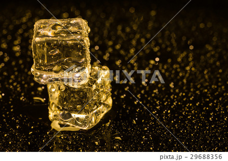Ice cubes in yellow light on black wet table. Ice cubes in yellow light on black wet table. 29688356