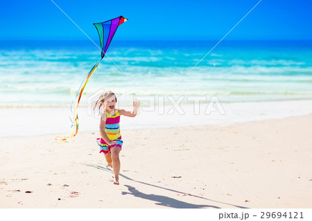 Child flying kite on tropical beach 29694121