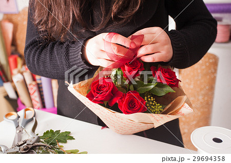 Florist making  bouquet of red roses 29694358