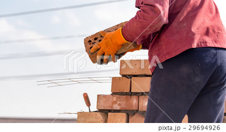 Worker builds a brick wall in the house 29694926