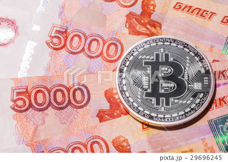 One Bitcoin on Russian rubles banknotes. 29696245
