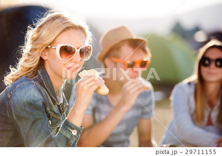 Teenagers sitting on the ground in front of tents Teenagers sitting on the ground in front of tents 29711155