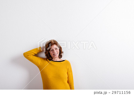 Senior woman in yellow woolen sweater, studio shot Senior woman in yellow woolen sweater, studio shot 29711156
