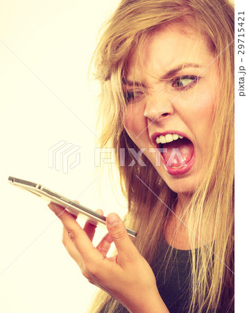 Angry young woman talking on phone 29715421