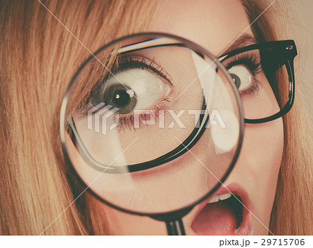 Woman holding magnifying glass investigating 29715706