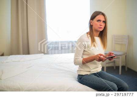 Young smiling woman sitting in the bed at home and Young smiling woman sitting in the bed at home and 29719777