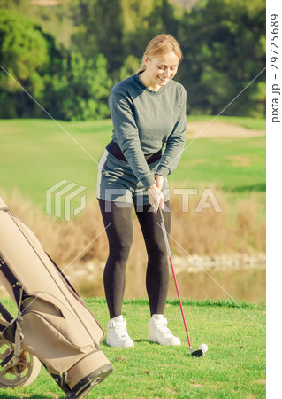 woman preparing to hit ball at golf course woman preparing to hit ball at golf course 29725689