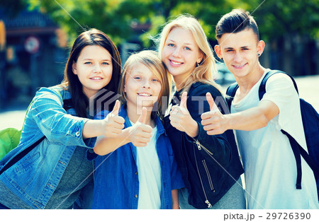 Four happy teenagers holding thumbs up together 29726390
